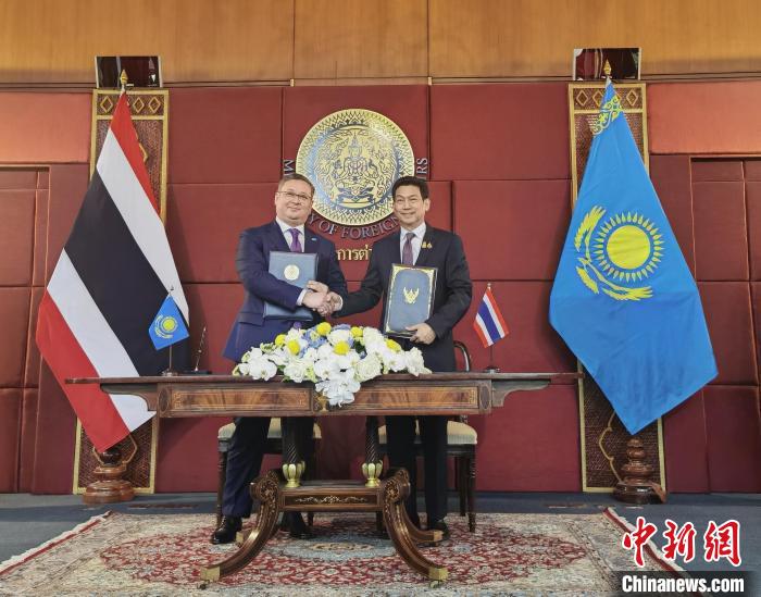 泰国副总理兼外交部长班比(右)与哈萨克斯坦副总理兼外交部长努尔特列乌(左)签署两国互免签证协议。李映民 摄